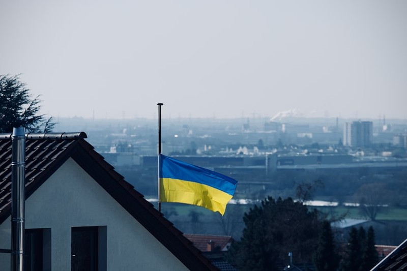 Ukrainian flag flying at half-staff against a gray sky