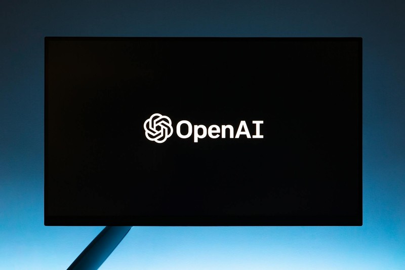 OpenAI logo displayed on a black screen against a gradient blue background