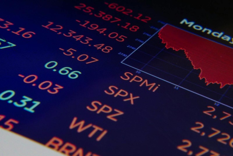 Financial data display showing stock market indices and oil prices with a declining red trend graph