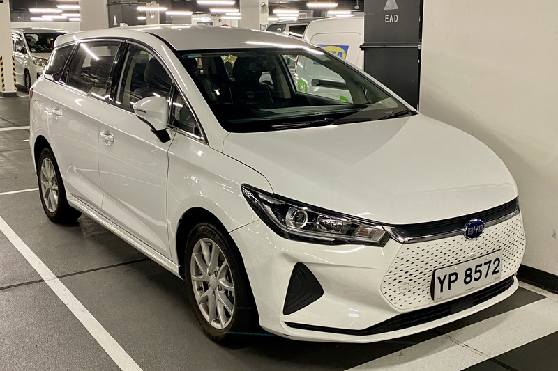 A white BYD e6 electric car parked in a parking garage in Hong Kong