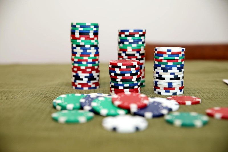Colorful stacks of poker chips on a green felt gambling table