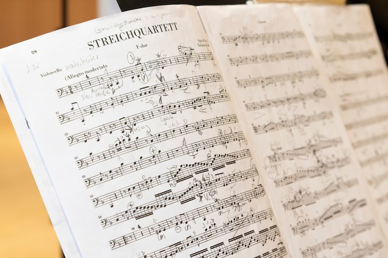 Sheet music for a string quartet with dense musical notation on an open page