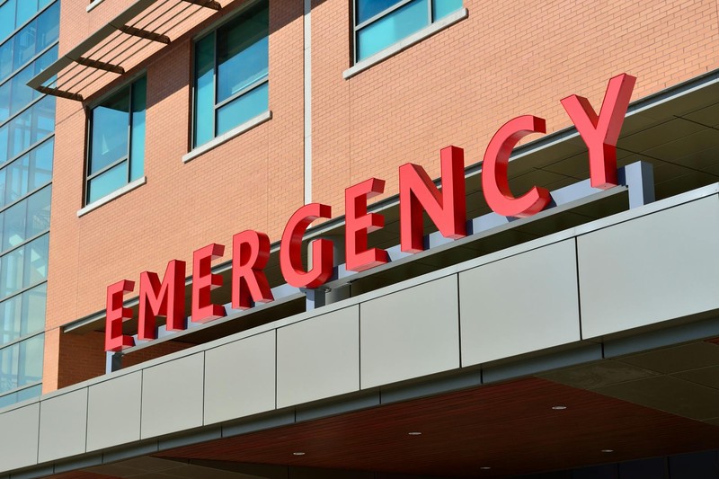 Hospital emergency room entrance with prominent red EMERGENCY sign