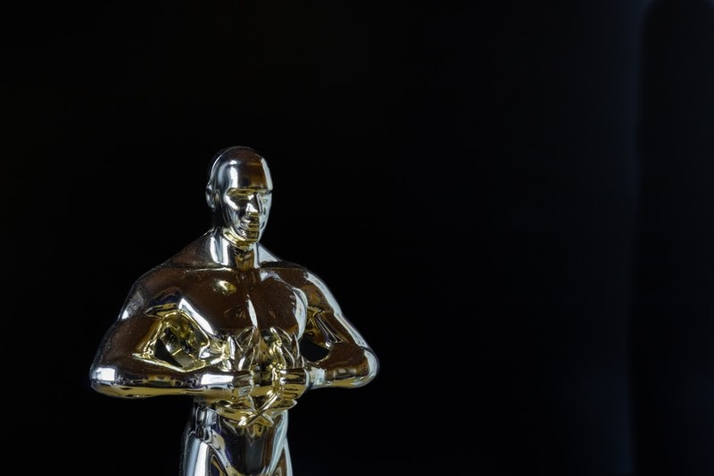 A golden Oscar statuette displayed against a black background