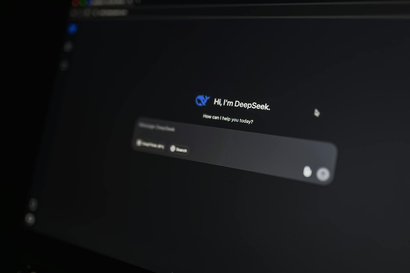 Laptop screen displaying the DeepSeek AI chat interface with its greeting message on a dark background