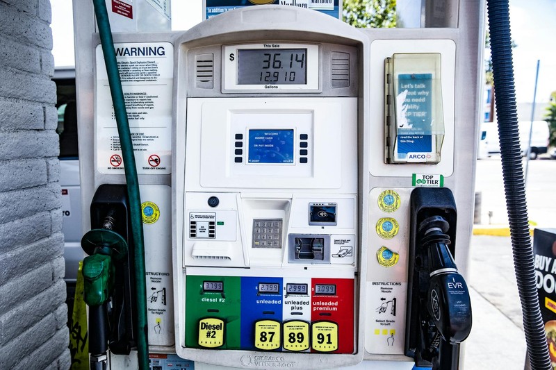 Close-up of a gas station fuel pump showing fuel grade buttons and digital display with transaction totals