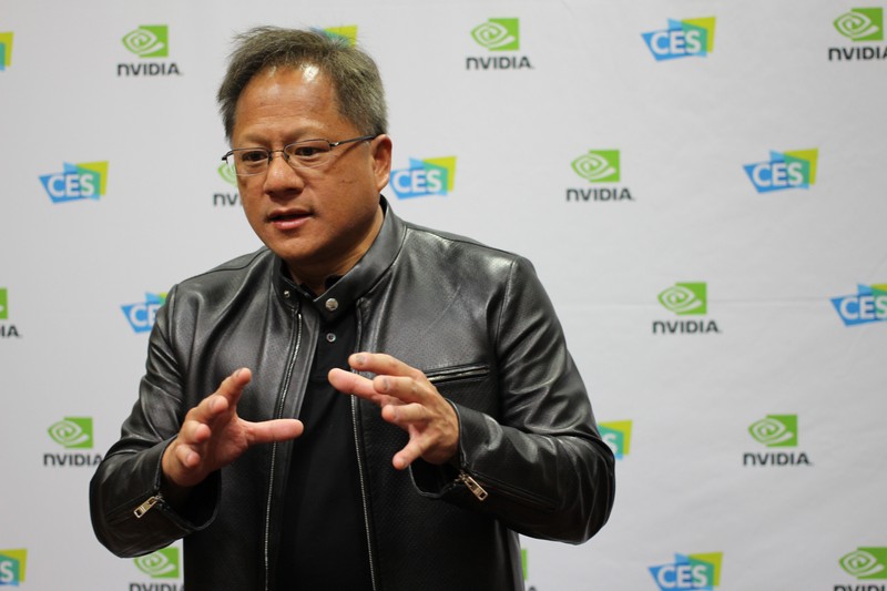 Nvidia CEO Jensen Huang speaking at a CES event with NVIDIA and CES branded backdrop