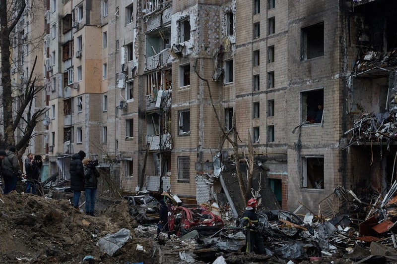 Heavily damaged multi-story residential building in Kyiv with debris and rescue workers in the aftermath of a Russian missile strike